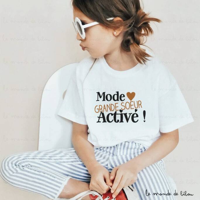 Annoncez la future arrivée d’un bébé avec notre t-shirt "Mode grande sœur/grand frère activé". Confortable et mignon, il est parfait pour marquer cette grande nouvelle avec amour et fierté !